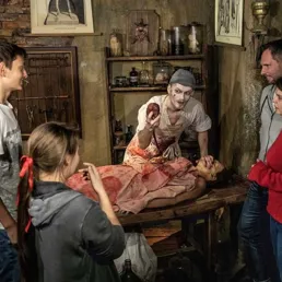 The plague doctor's assistant happily welcomes visitors to the Berlin Dungeon.